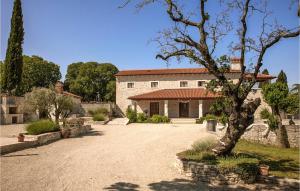 un grand bâtiment en pierre avec un arbre devant dans l'établissement Villa Marija Korenici, à Rovinj