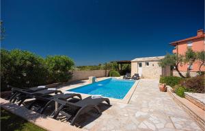 a swimming pool with chairs next to a house at Villa Macun in Rovinj