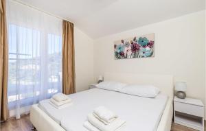 a white bedroom with a white bed and a window at Cozy Home In Mundanije With Wifi in Mundanije