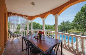 a porch with a wooden table and chairs at Three-Bedroom Holiday Home In Nedescina in Nedeščina