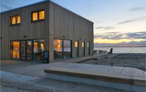 a building on a dock near the water at sunset at Beach Front Home In Lembruchdümmer See in Lembruch