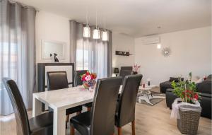 a dining room and living room with a table and chairs at Amazing Home In Pula With Kitchen in Pula