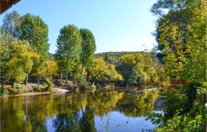 a river with trees reflecting in the water at St Marie in Sarlat-la-Canéda