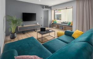 a living room with a blue couch and a tv at Cozy Home In Banjole With Wifi in Banjole