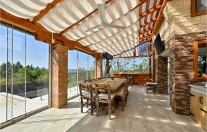 a dining room with a wooden table and large windows at Stunning Home In Donja Poljana in Donja Poljana