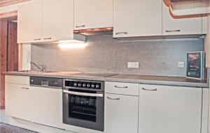 kuchnia z białymi szafkami i kuchenką w obiekcie Ferienwohnung In Kappl-Paznaun w mieście Kappl