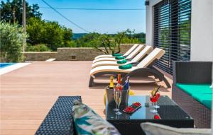 un patio con 2 sillas y una mesa con bebidas. en Villa Pedena, en Benažići