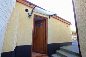 a door to a building with stairs next to it at Sound of the River in Talgarth