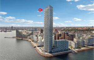 a tall building with a red spot on it in a city at Light House in Aarhus