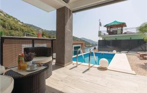einen Balkon mit einem Tisch und einem Pool in der Unterkunft Four-Bedroom Apartment In Klek in Klek