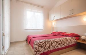 a bedroom with a bed with red sheets and a window at Holiday Home Barbariga 01 in Barbariga