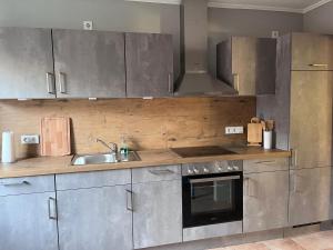 a kitchen with stainless steel cabinets and a sink at Ferienhaus Sonnendeich in Emmelsbüll-Horsbüll