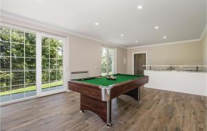 a pool table in a large room with windows at Gorgeous Home In Bregi With Kitchen in Breza