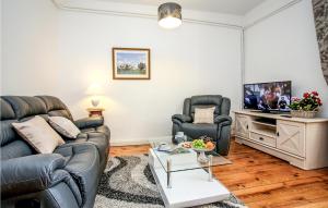 a living room with a couch and two chairs and a tv at St Marie in Sarlat-la-Canéda