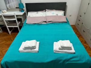 a blue bed with towels on it in a bedroom at Apartman Ristić in Pirot +6 photos