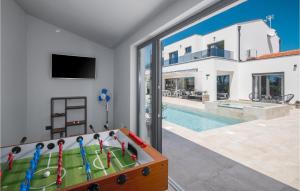 a pool table in a living room next to a swimming pool at Cozy Home In Banjole With Wifi in Banjole +42 photos