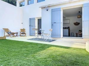 a backyard with a lawn and a house at Le Romarin Bas de villa T2 avec jardin et parking au pied de la Forêt in La Penne-sur-Huveaune