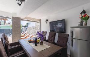 ein Esszimmer mit Tisch und Kühlschrank in der Unterkunft Four-Bedroom Apartment In Klek in Klek + 21 Fotos