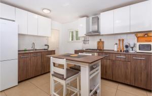 a kitchen with white cabinets and a wooden island in it at 4 Bedroom Pet Friendly Home In Malinska in Malinska