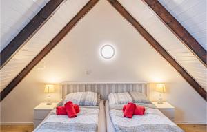 フリードリッヒシュコオクにあるAwesome Apartment In Friedrichskoogの屋根裏のベッドルーム(赤い枕付)のベッド2台 +5枚の写真