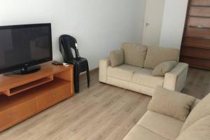 un salon avec un canapé et une télévision à écran plat dans l'établissement Apartamento completo para até 9 pessoas, à Ribeirão Preto