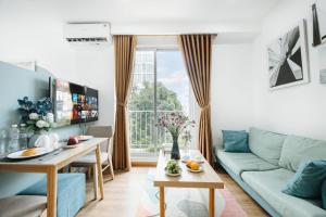 Una sala de estar con un sofá azul y una mesa. en The Euphoria Sophisticated Style - Stay 24h, en Hanói 75 fotos más