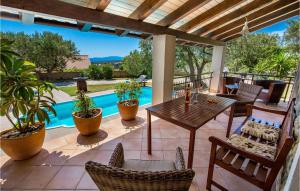 a patio with a table and chairs and a pool at 3 Bedroom Cozy Home In Palit in Palit