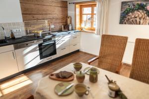 een keuken met een tafel en een fornuis bovenste oven bij Ferienwohnung Landhaus Martin in Sonthofen