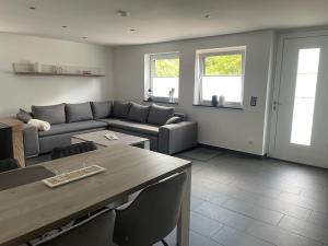 una sala de estar con un sofá y una mesa en Ferienwohnung Biggesee, en Drolshagen