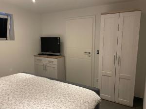 Un dormitorio con una cama y un televisor de pantalla plana. en Ferienwohnung Biggesee, en Drolshagen