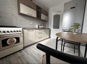 a kitchen with a stove and a table in it at A&B Apartaments1 in Târgu Ocna
