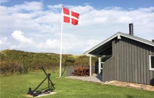 a flag on a pole in front of a building at Holiday Home Vestervig With A Fireplace 164 in Agger