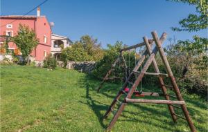 Drewniana huśtawka na podwórku z domem w obiekcie Holiday Home Mio Persan Cr w mieście Rakalj