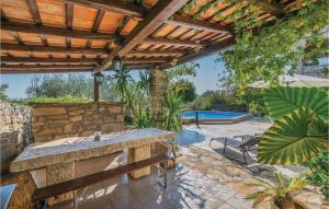 patio z kamiennym stołem i drewnianą pergolą w obiekcie Holiday Home Mio Persan Cr w mieście Rakalj +37 zdjęć