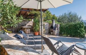 grupa krzeseł i stół z parasolem w obiekcie Holiday Home Mio Persan Cr w mieście Rakalj