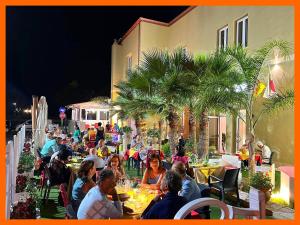 a group of people sitting at tables at a restaurant at Stellaris in Siderno Marina