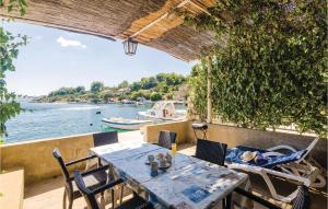 a table and chairs on a deck with a view of the water at Apartment Banici Ii in Slano