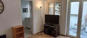 a living room with a flat screen tv on a dresser at Studio indépendant de plain pied agréé Chèques Vacances in Drancy