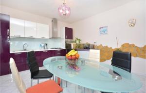 una cocina con una mesa de cristal con fruta. en Four-Bedroom Apartment In Srinjine, en Srinjine