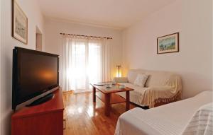a living room with a flat screen tv and a couch at Holiday Home Put Vrljuge Iv in Sukošan