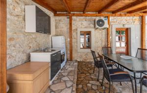 kuchnia i jadalnia ze stołem i krzesłami w obiekcie Gorgeous Home In Lisane Tinjske w mieście Lišane Tinjske