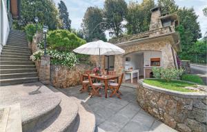 Un patio con una mesa de madera y una sombrilla. en Amazing Home In Camaiore Lu With Wifi, en Camaiore