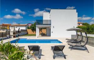 a villa with a swimming pool and two chairs and an umbrella at Villa Lumalu in Orbanići +46 photos