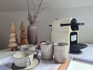 a group of cups sitting on a counter next to a toaster at L'escale champêtre in Uhrwiller