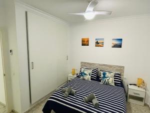 A bed or beds in a room at Apartamento Conil Playa & céntrico, con Aire Acond y WIFI -SOLO FAMILIAS Y PAREJAS-