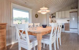 una sala da pranzo con tavolo in legno e sedie bianche di Holiday Home Sønder Vasevej Blåvand Iv a Blåvand