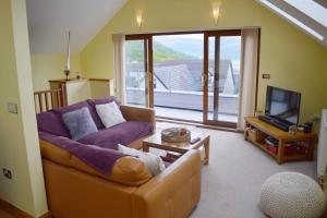 un salon avec un canapé et une télévision dans l'établissement Ruby's Watch, à Barmouth