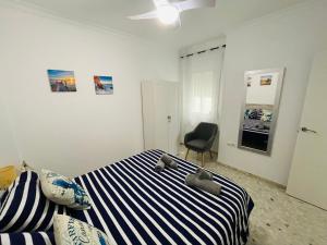 A bed or beds in a room at Apartamento Conil Playa & céntrico, con Aire Acond y WIFI -SOLO FAMILIAS Y PAREJAS-