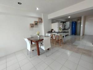 ポルラマルにあるMENINA Beach Apartmentのテーブルと椅子のあるキッチンとダイニングルーム