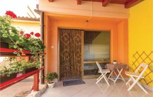 weranda z 2 krzesłami i drewnianymi drzwiami w obiekcie Apartment Fazana - 07 w Fažanie